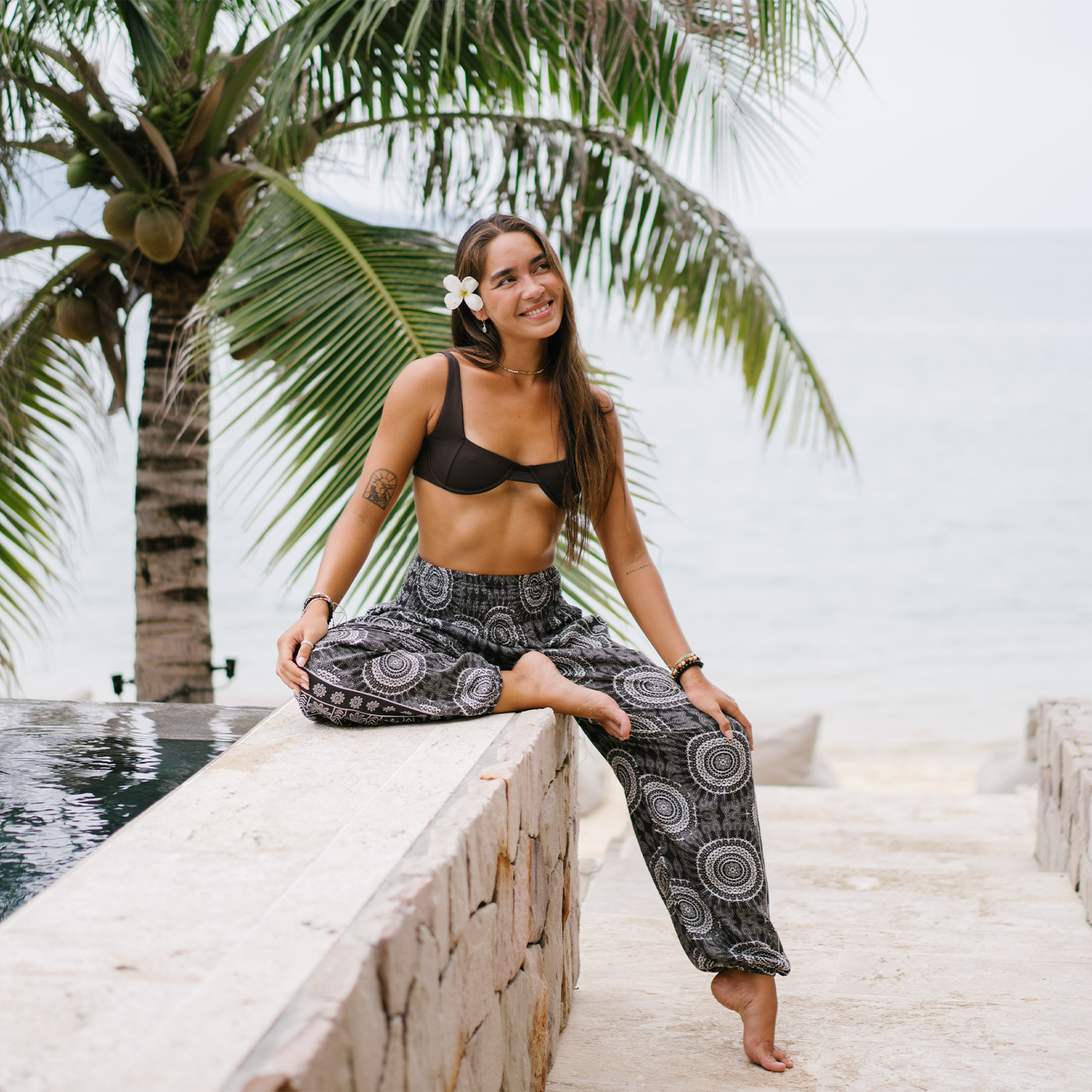 Model wearing faded black and cream mandala print harem pants